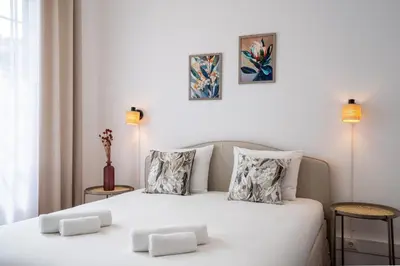 a bedroom with a white bed with two pillows at Zarco Suites by Sé Funchal in Funchal