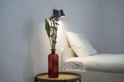a red vase sitting on a table next to a bed at Zarco Suites by Sé Funchal in Funchal