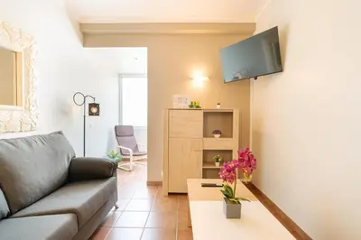 a living room with a couch and a tv on a wall at Lido Escape in Funchal