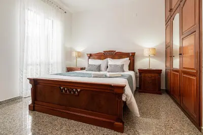a bedroom with a large wooden bed and two lamps at Casa Carreiro in Paul do Mar