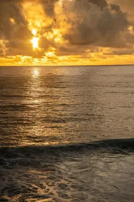 a sunset over the ocean with the sun setting at Casa Carreiro in Paul do Mar