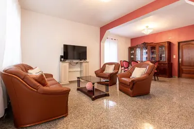 a living room with leather chairs and a flat screen tv at Casa Carreiro in Paul do Mar