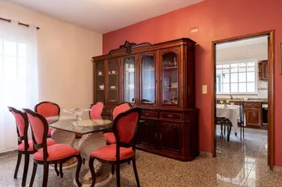 a dining room with a table and chairs and a cabinet at Casa Carreiro in Paul do Mar