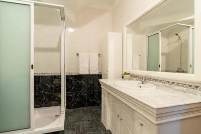 a white bathroom with a sink and a shower at Casa Carreiro in Paul do Mar