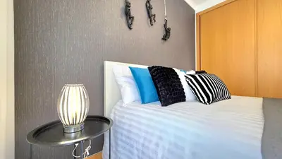 a bedroom with a bed and a table with a lamp at Casa Dama Ana in Caniço