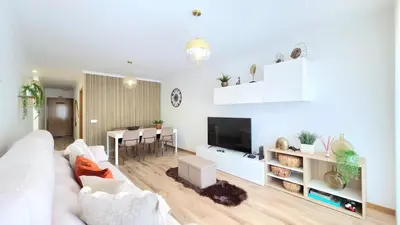 a living room with a white couch and a table at Casa Dama Ana in Caniço