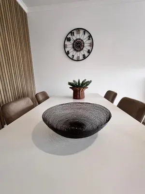 a table with a round seat on a table with a clock at Casa Dama Ana in Caniço