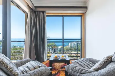 a living room with two couches and a large window at Views of Madeira by Atlantic Holiday in Ilhéu do Gorgulho