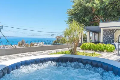 a hot tub with the ocean in the background at Villa Santa Luzia 1 by Atlantic Holiday in Santa Luzia