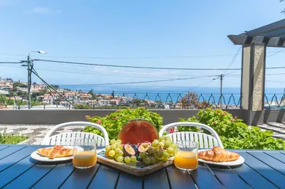 a table with a tray of fruit and orange juice at Villa Santa Luzia 1 by Atlantic Holiday in Santa Luzia