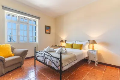 a bedroom with a bed and a couch at Villa Santa Luzia 1 by Atlantic Holiday in Santa Luzia
