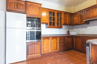 a kitchen with wooden cabinets and a white refrigerator at Villa Santa Luzia 1 by Atlantic Holiday in Santa Luzia