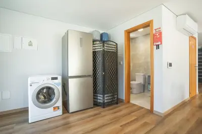 a laundry room with a refrigerator and a washing machine at Villa Lorenzo by Atlantic Holiday in São Vicente