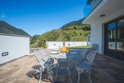 a patio with a table and chairs on a deck at Villa Lorenzo by Atlantic Holiday in São Vicente