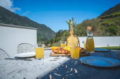 a table with a glass of orange juice and a bottle at Villa Lorenzo by Atlantic Holiday in São Vicente