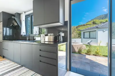 a kitchen with a view of a patio at Villa Lorenzo by Atlantic Holiday in São Vicente
