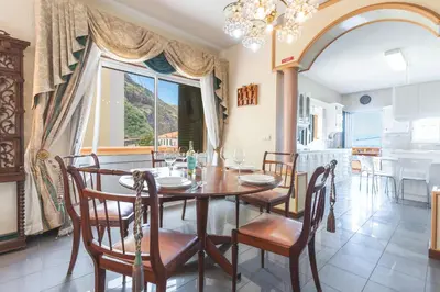 a dining room with a table and chairs and a kitchen at Villa Mar by Atlantic Holiday in Porto Moniz