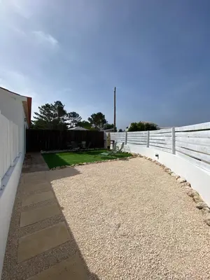 a walkway next to a white fence and a yard at Casa Vinny in Aljezur