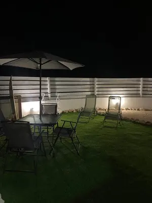a table and chairs with an umbrella in a yard at night at Casa Vinny in Aljezur