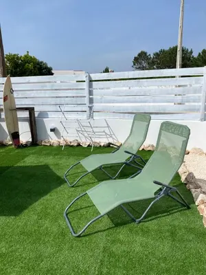 two green lawn chairs sitting on the grass at Casa Vinny in Aljezur