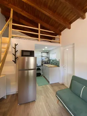 a kitchen and living room with a couch and a refrigerator at Casa Vinny in Aljezur