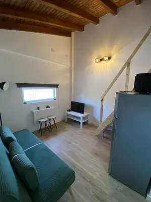 a living room with a blue couch and a staircase at Casa Vinny in Aljezur