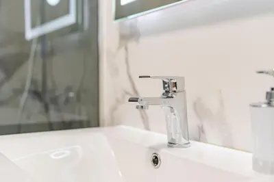a bathroom sink with a faucet and a mirror at atlantico view in Caniço