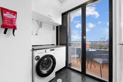 a washing machine in a laundry room with a balcony at atlantico view in Caniço