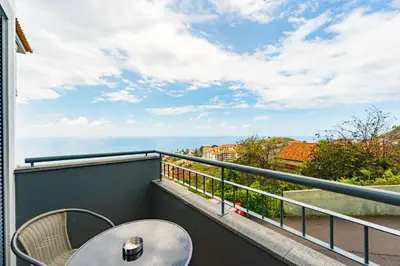 a balcony with a table and a view of the ocean at atlantico view in Caniço