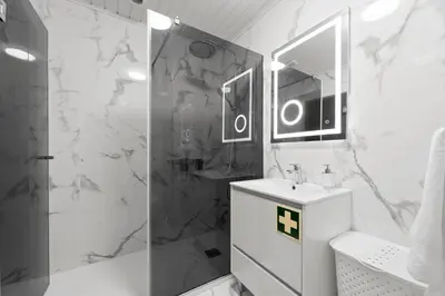 a white bathroom with a shower and a sink at atlantico view in Caniço