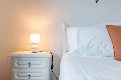 a bed with a nightstand with a lamp on it at atlantico view in Caniço