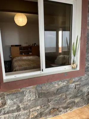 two windows in a room with a bed and a bedroom at Casa Maria in Ribeira Brava