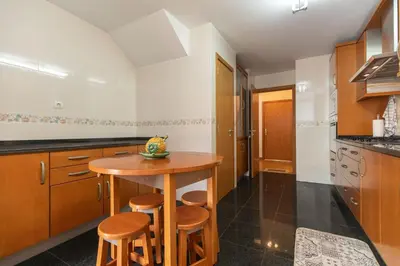 a kitchen with a wooden table and stools at Anadia Penthouse Duplex by Rent-a-key in Funchal