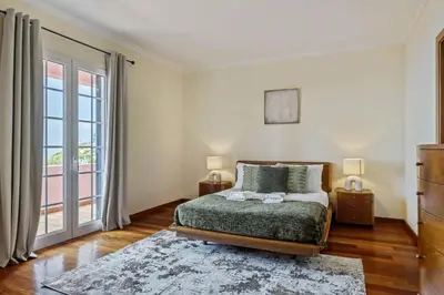 a bedroom with a bed and a large window at Amendoeira Residence by Homie in Ponta do Sol