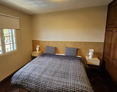 a bedroom with a bed with blue and white checked sheets at Moradia em Ponta do Sol 2 Quartos in Ponta do Sol
