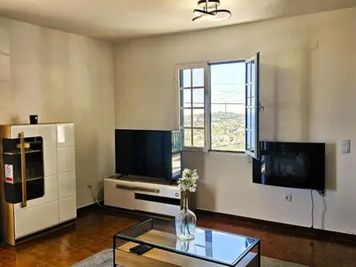 a living room with a vase of flowers on a table at Moradia em Ponta do Sol 2 Quartos in Ponta do Sol