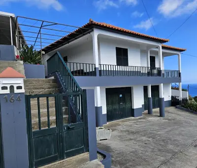 a white house with a green door and a gate at Moradia em Ponta do Sol 2 Quartos in Ponta do Sol