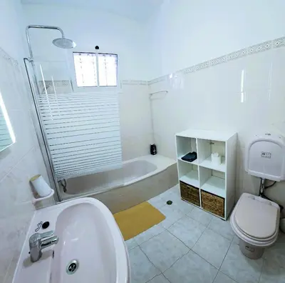 a bathroom with a sink and a tub and a toilet at Moradia em Ponta do Sol 2 Quartos in Ponta do Sol