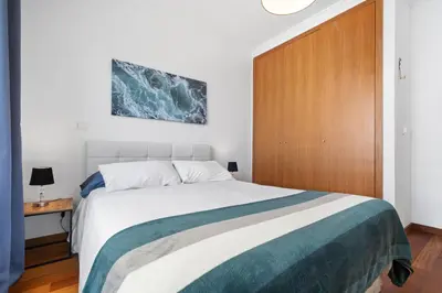 a bedroom with a large bed and a wooden door at Madalenas Holiday Retreat - Free Parking in Funchal in Funchal