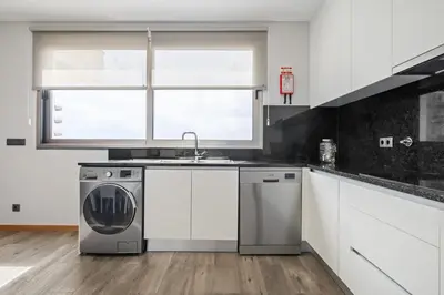 a kitchen with white cabinets and a dishwasher at Casa das Raposinhas VII in Funchal