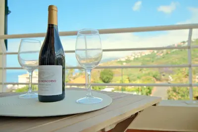 a bottle of wine and two glasses on a table at MG Hollidays in Funchal