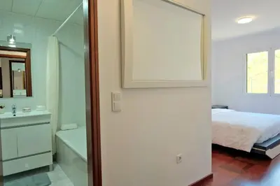 a bedroom with a bed and a bath tub and a mirror at MG Hollidays in Funchal