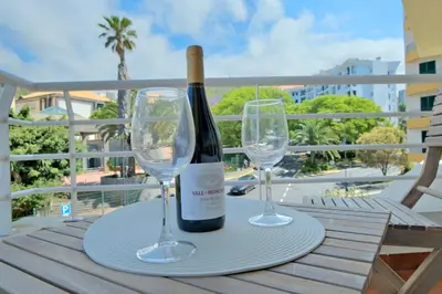 a bottle of wine and two wine glasses on a table at MG Hollidays in Funchal