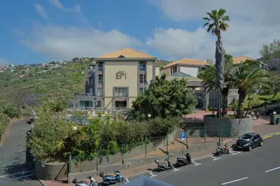 a building with motorcycles parked in front of a street at MG Hollidays in Funchal