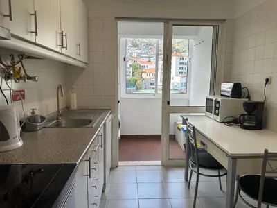 a kitchen with a sink and a counter with a microwave at Aqua City Center in Funchal