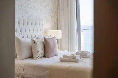 a bedroom with a white bed with pillows and a window at The Ocean Gaze by Homie in Funchal