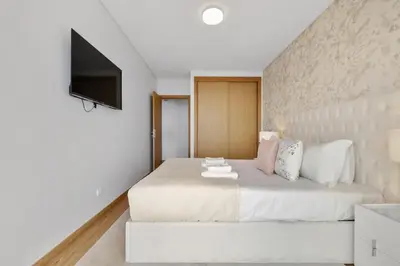 a bedroom with a large white bed with a flat screen tv at The Ocean Gaze by Homie in Funchal
