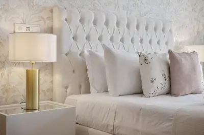 a bed with white pillows and a table with a lamp at The Ocean Gaze by Homie in Funchal