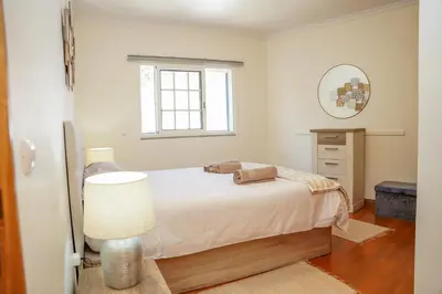 a white bedroom with a bed and a mirror at Rosária Flat in Santa Cruz