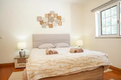 a bedroom with a large bed with two towels on it at Rosária Flat in Santa Cruz